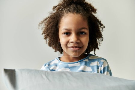 Foto de Una joven, vestida en pijama, se esconde juguetonamente detrás de una almohada, trayendo alegría y risa a la escena. - Imagen libre de derechos