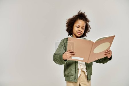 Una niña absorta en leer un libro sobre un fondo blanco.