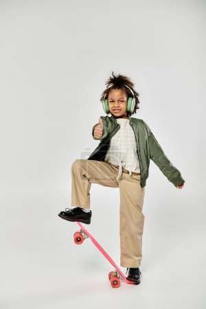 Photo for Stylish African American girl skateboarder gliding wearing headphones. - Royalty Free Image