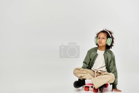 A young African American girl with curly hair sits on a skateboard, headphones on, lost in music.