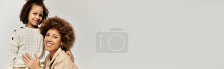 Photo for Two curly African American women hug each other on a white background, showing love and connection. - Royalty Free Image