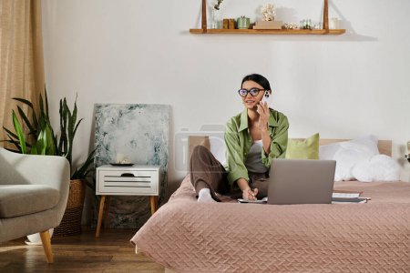A person sitting on a bed, using a laptop for remote work.