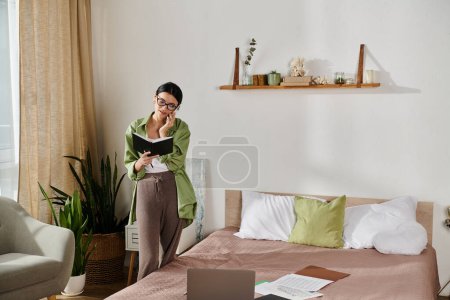 Woman immersed in book reading in bedroom, phone call.