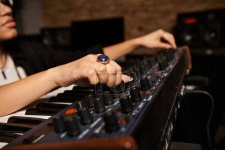 Una persona toca un teclado electrónico en un estudio de grabación durante un ensayo de la banda de música.