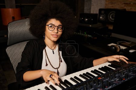 A talented woman in glasses plays a keyboard with passion and focus in a recording studio during a music band rehearsal.