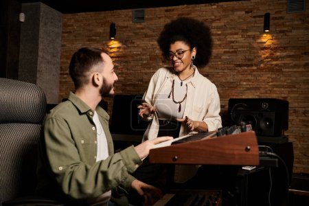A woman and a man are collaborating on music in a recording studio during a band rehearsal session.