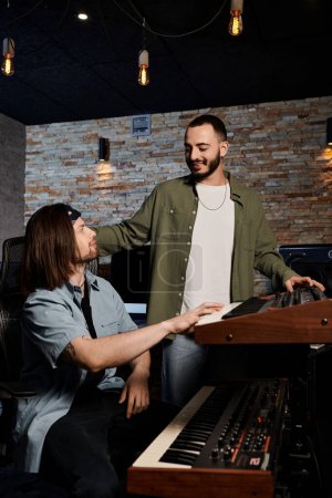 Deux musiciens talentueux se tiennent dans un studio d'enregistrement, collaborant sur la musique pour leurs groupes prochain projet.