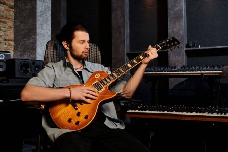 Un hombre experto tocando una guitarra eléctrica en un estudio de grabación como parte de un ensayo de la banda de música.
