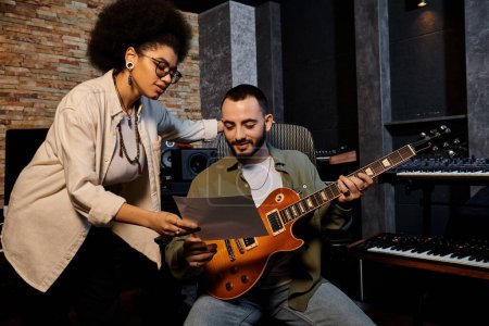 A man and woman passionately play guitars in a recording studio during a music band rehearsal.