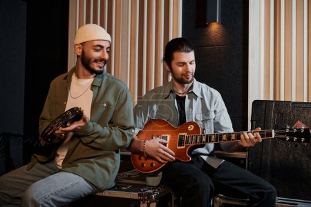 Two men passionately playing guitars in a recording studio during a music band rehearsal.