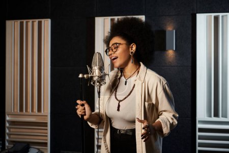 Talented woman pouring her heart into singing with a microphone in a professional recording studio during band rehearsal.