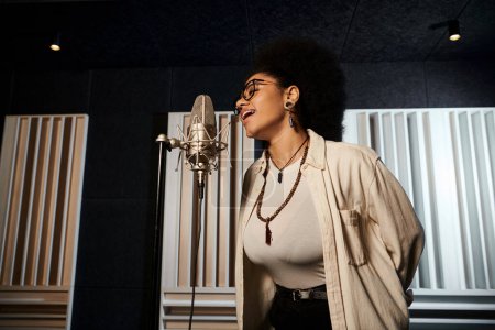 A woman passionately singing into a microphone in a recording studio during a music band rehearsal.