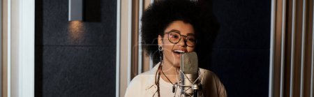 Téléchargez les photos : Une femme chante passionnément dans un micro d'un studio d'enregistrement professionnel lors d'une répétition d'un groupe de musique. - en image libre de droit