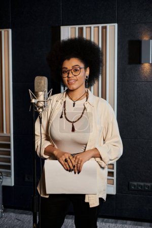 A talented woman stands poised in front of a microphone, ready to lend her voice to a music band rehearsal in a recording studio.