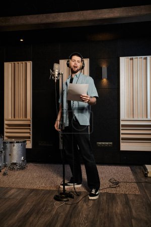 Un homme, membre d'un groupe de musique, se tient en confiance devant un microphone dans un studio d'enregistrement, prêt à mettre en valeur son talent.
