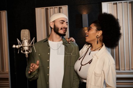 Téléchargez les photos : A man and woman stand side by side in a recording studio, immersed in rehearsing for their music band. - en image libre de droit
