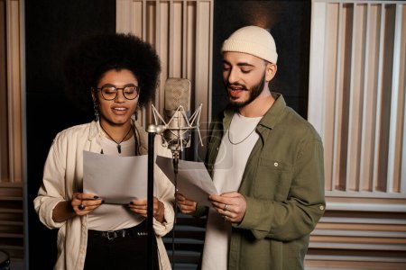 A man and woman harmonize as they sing in a recording studio during music band rehearsal.