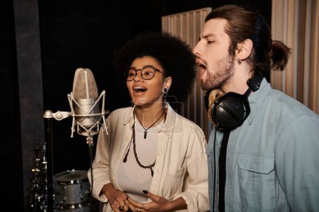 Un homme et une femme chantent passionnément dans les micros d'un studio d'enregistrement, entourés d'instruments de musique.