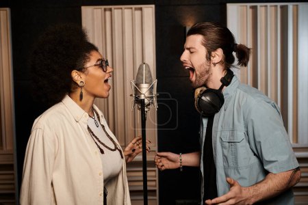 A man and woman passionately singing into a microphone in a recording studio during a music band rehearsal.