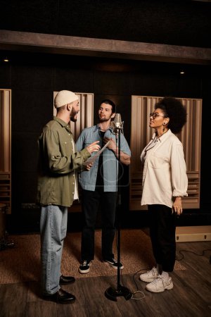 A diverse group of musicians standing in a recording studio during a band rehearsal session.