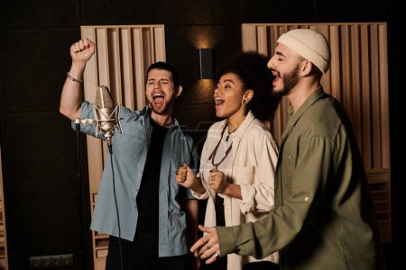 Tres individuos cantan apasionadamente en el micrófono en un estudio de grabación durante un ensayo de la banda de música.