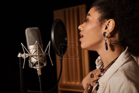 Une femme talentueuse chante passionnément dans un micro tout en enregistrant dans un studio de musique avec son groupe.