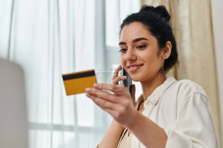 Eine Frau beim Multitasking mit Kreditkarte und Handy.