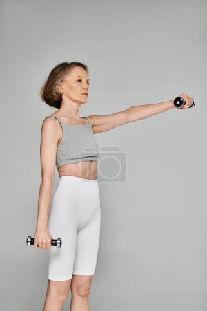 Téléchargez les photos : Femme attrayante en tenue active tenant haltère - en image libre de droit