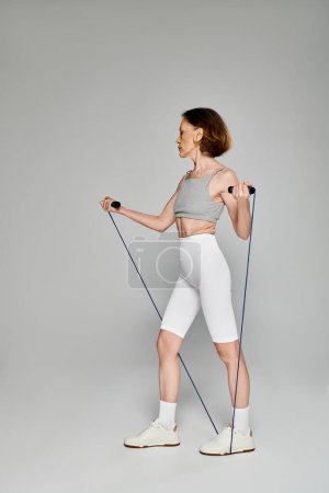 Reife Frau in aktiver Kleidung mit Seil für Widerstandstraining.