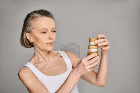 A woman gazes upon a tall stack of cream jars.