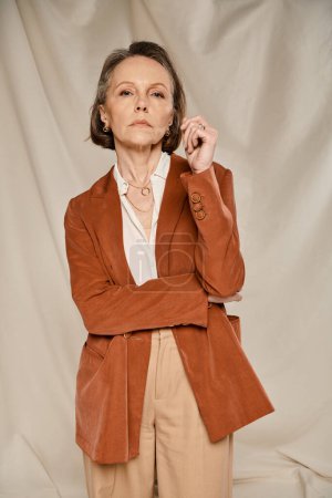 Stylish woman in brown jacket and tan pants striking a pose.