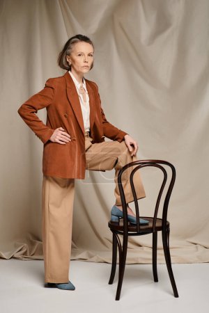 Weiser Ältester in legerer Kleidung posiert selbstbewusst auf einem Stuhl sitzend.