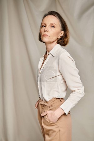 Mature woman in tan pants and white shirt.