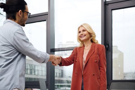 Woman and man exchanging handshake in modern office setting.