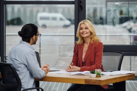 Buscador de empleo entrevista en un escritorio de oficina moderna por mujer.