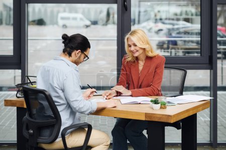 Un homme et une femme engagés dans une conversation à un bureau dans un bureau.