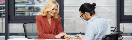 Photo for Two women engaged in a deep conversation at a desk. - Royalty Free Image