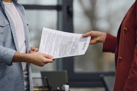 Foto de El hombre entrega papel a su empleador en una oficina. - Imagen libre de derechos