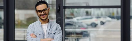 Téléchargez les photos : Un homme avec des lunettes se tient contemplativement devant une fenêtre. - en image libre de droit