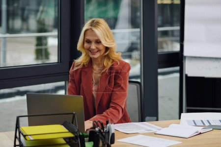 Téléchargez les photos : Une femme travaille sur un ordinateur portable à un bureau. - en image libre de droit