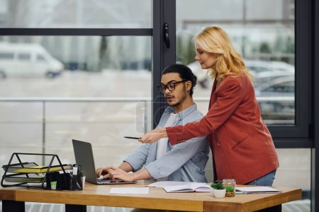Ein Mann und eine Frau konzentrieren sich in einem Büro auf einen Laptop.