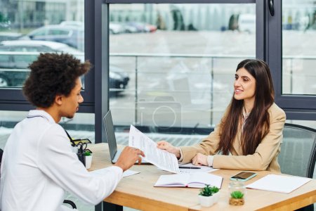 Two people engrossed in conversation at table during job interview.