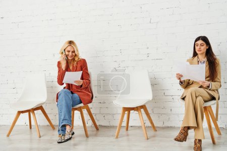 Grupo de mujeres en sillas, en espera de una entrevista de trabajo.