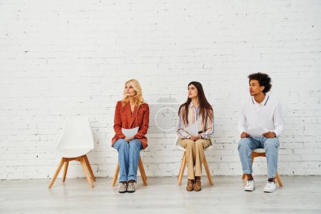 People sitting in chairs in front of a plain white wall.