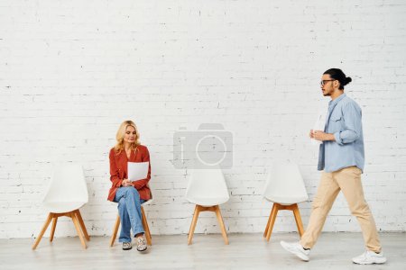 Man and woman engaging in conversation against a white wall.