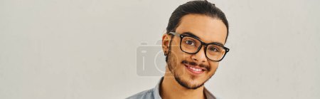 Téléchargez les photos : Un homme avec des lunettes souriant sur fond blanc. - en image libre de droit