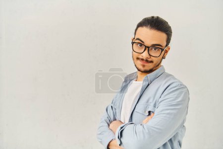 Photo for A stylish young man poses confidently in glasses. - Royalty Free Image
