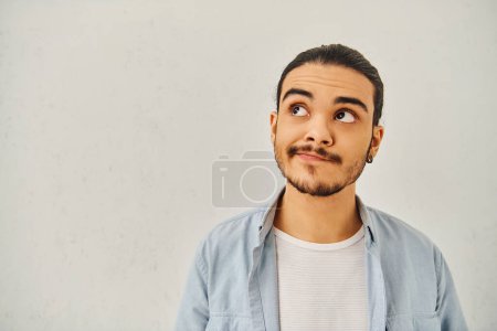 Ein Mann mit stylischem Schnurrbart blickt in die Kamera.