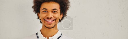 Photo for Smiling man with curly hair in front of white background. - Royalty Free Image