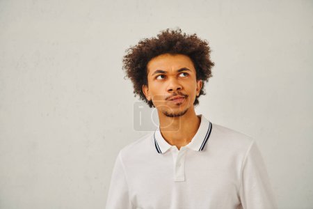 Photo for A man in a white polo shirt looking up at the camera. - Royalty Free Image